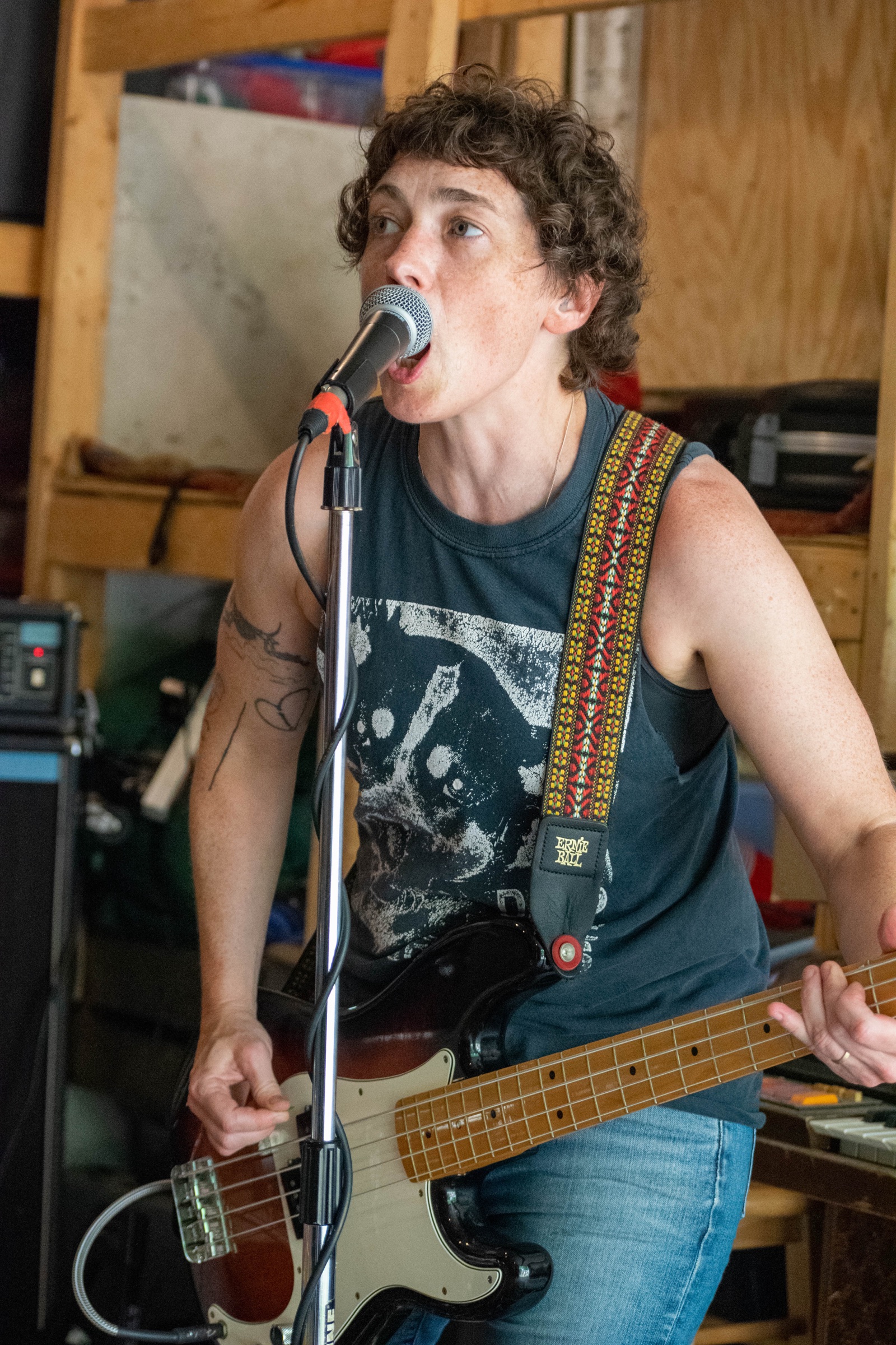 A bassist singing into a microphone in a garage